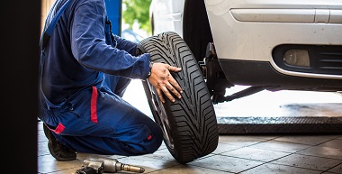 Tire technician working on car in Bonney Lake, WA